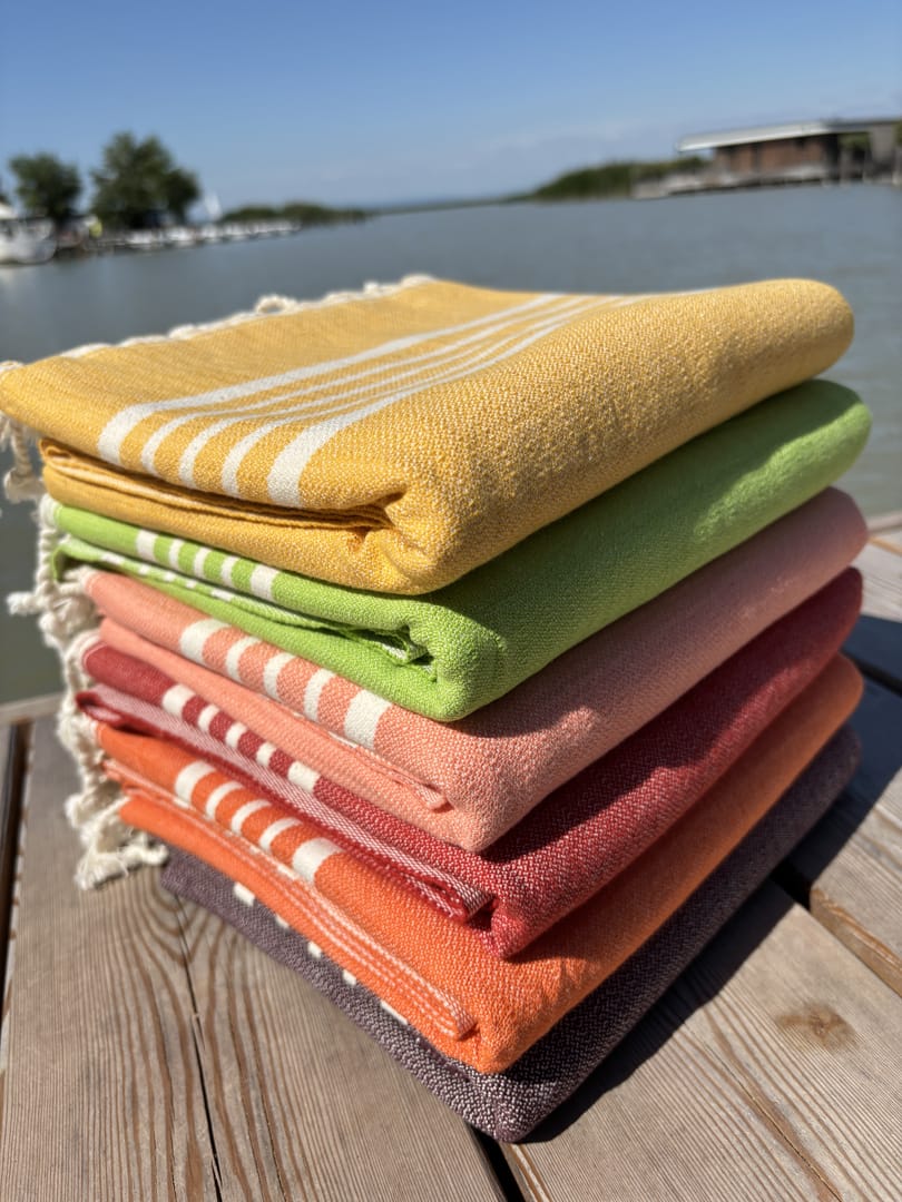 Hamamtuch ALMA – Strandtücher für Sommer in Farben Gelb, Limette, Lachsrosa, Rot, Orange und Dunkelbraun zusammengelegt am Strand -DENIO