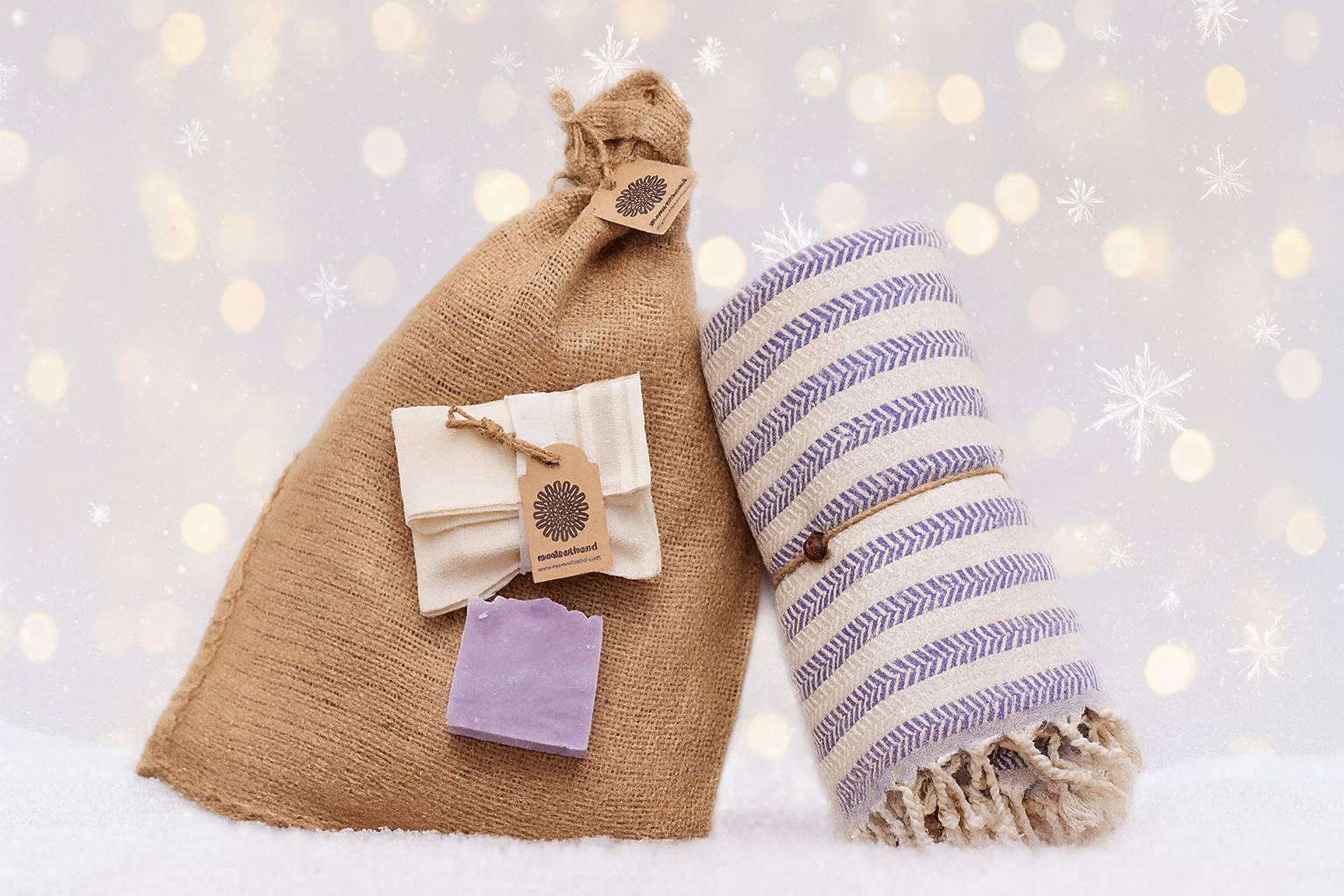 Hamamtuch aus 100 % Baumwolle in Rot mit feinem Fischgrätmuster und weißen Fransen, kombiniert mit weißer Peeling Handschuh und hellblauer Naturseife – stilvolles Wellness- und Reiseaccessoire von DENIO Home.