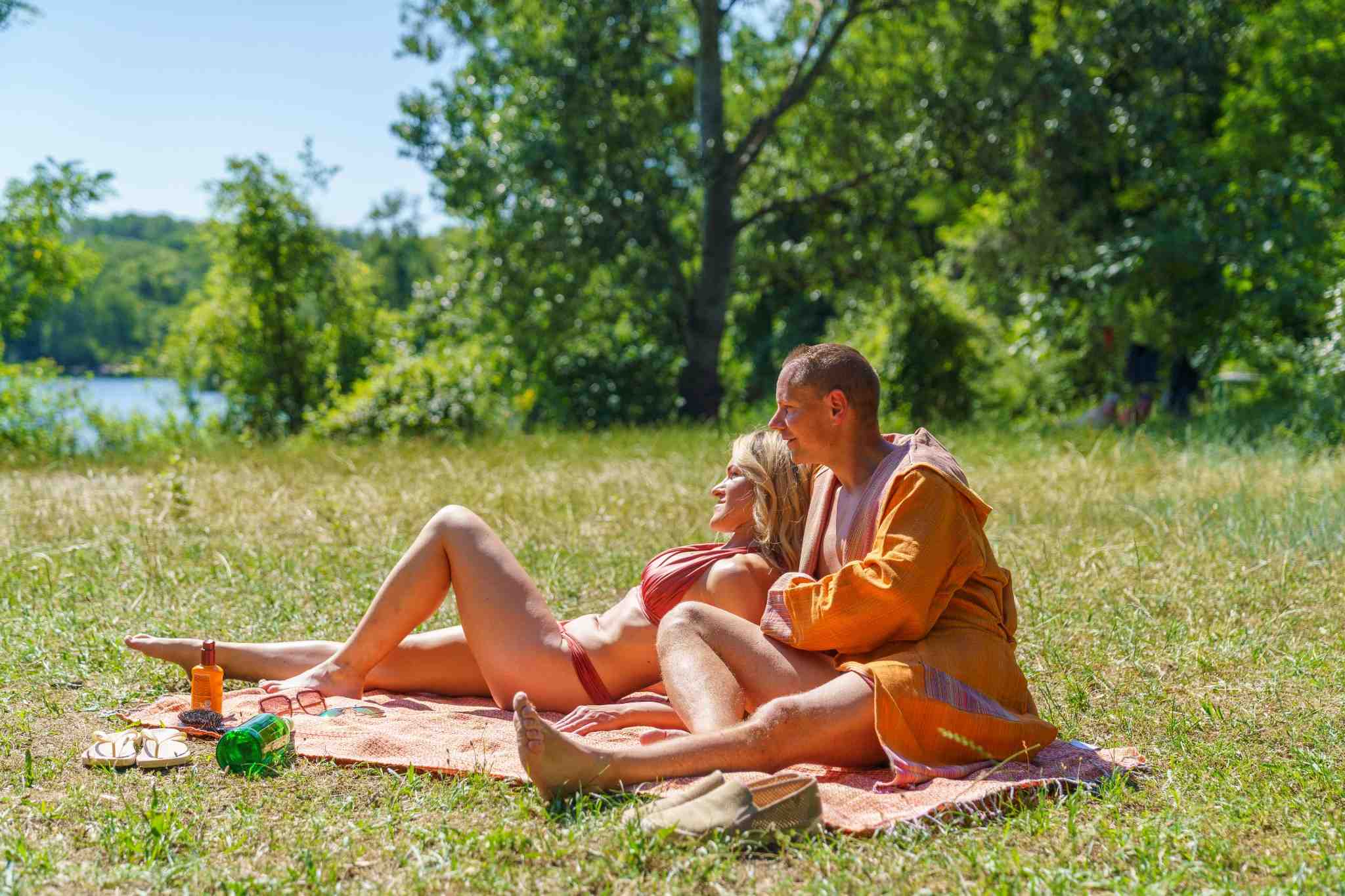 Paar entspannt am See auf einem Hamamtuch aus Baumwolle – leichtes Strandtuch und Reisehandtuch von DENIO