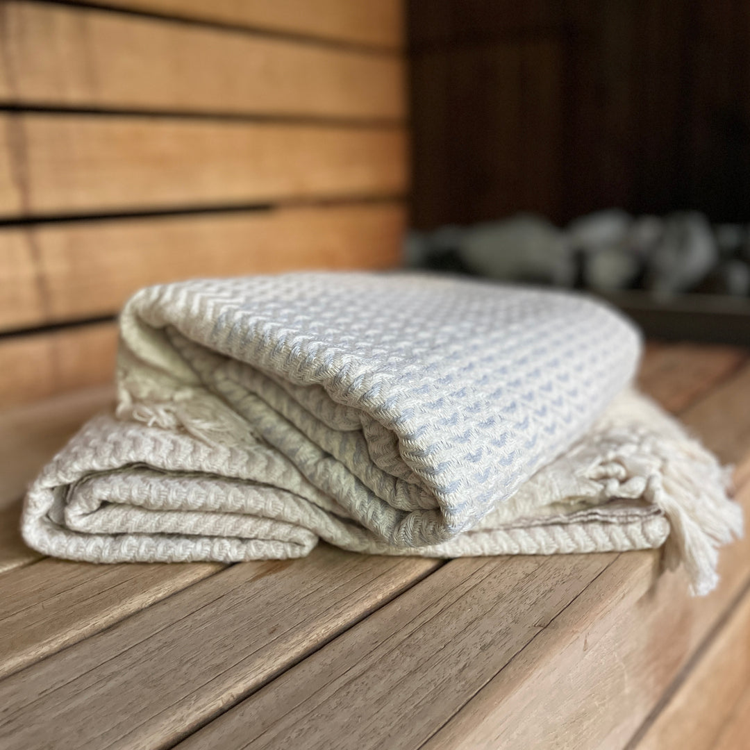 Hamamtuch auf einer Bank in der Sauna in Farbe Grau