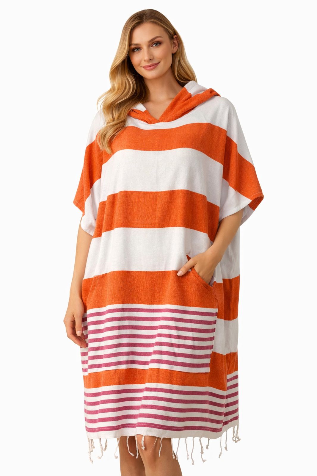 Frau trägt orange und weiß gestreiften Baumwoll-Poncho mit Kapuze und Fransen vor weißem Hintergrund.